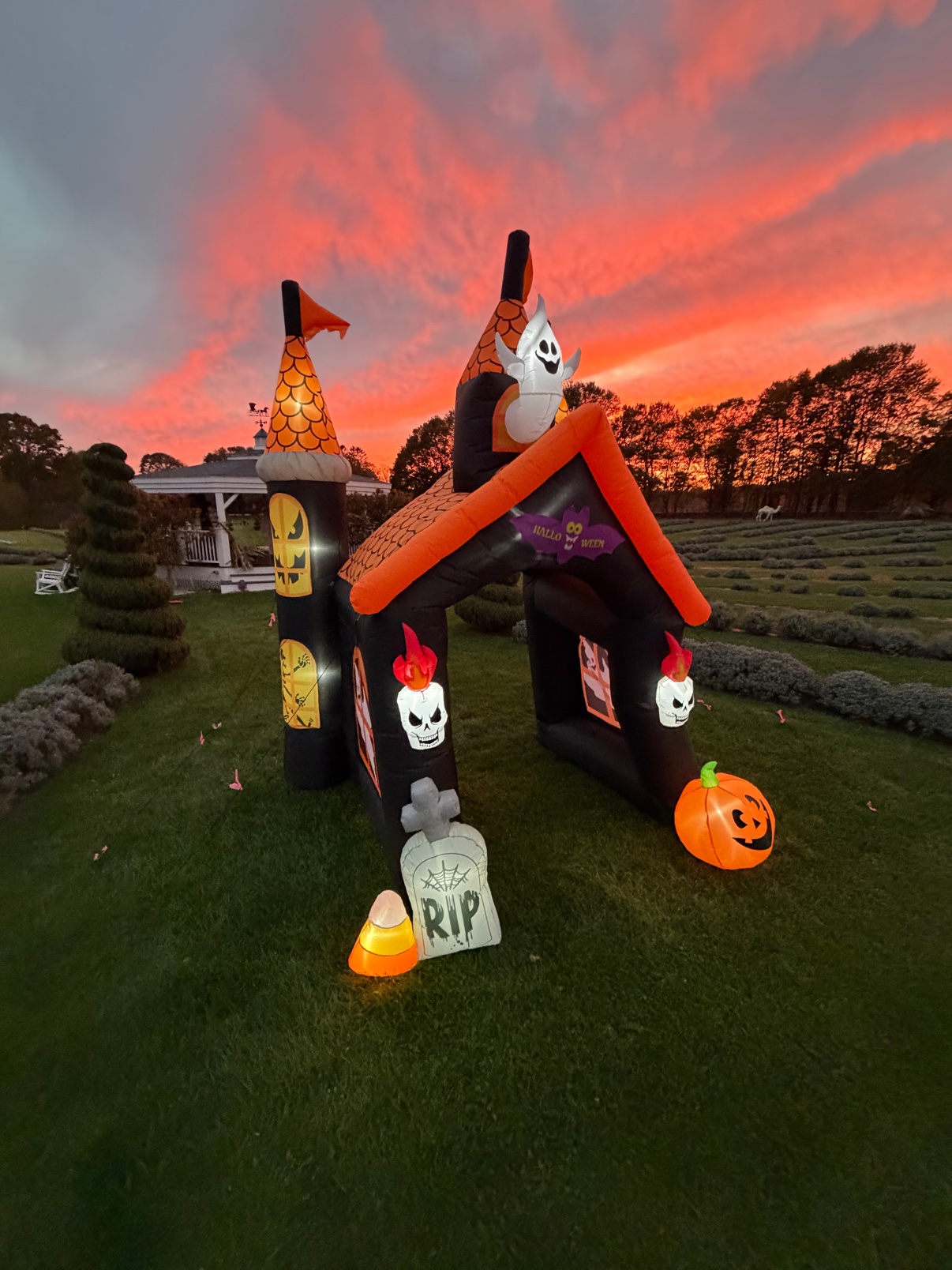 The inflatable Halloween castle lit up under a blazing sunset sky