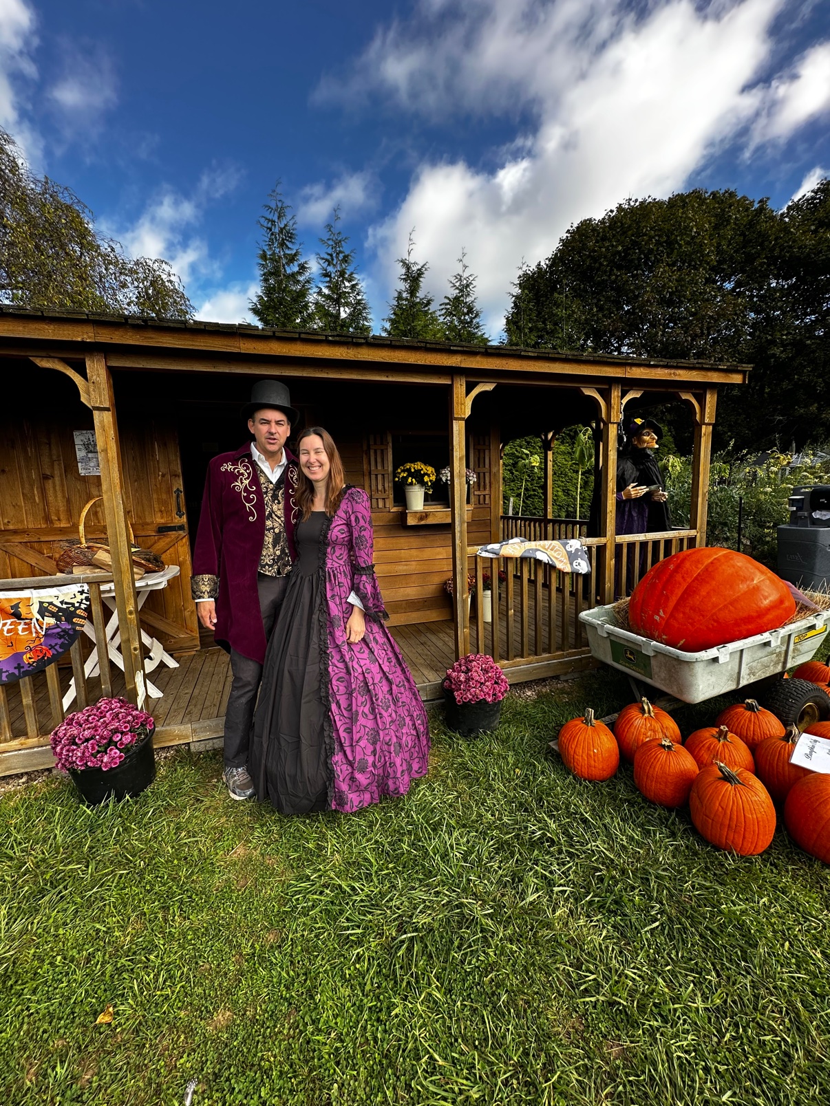 Henry and Rebecca in costume by the farm shop, with the giant pumpkin in the wagon