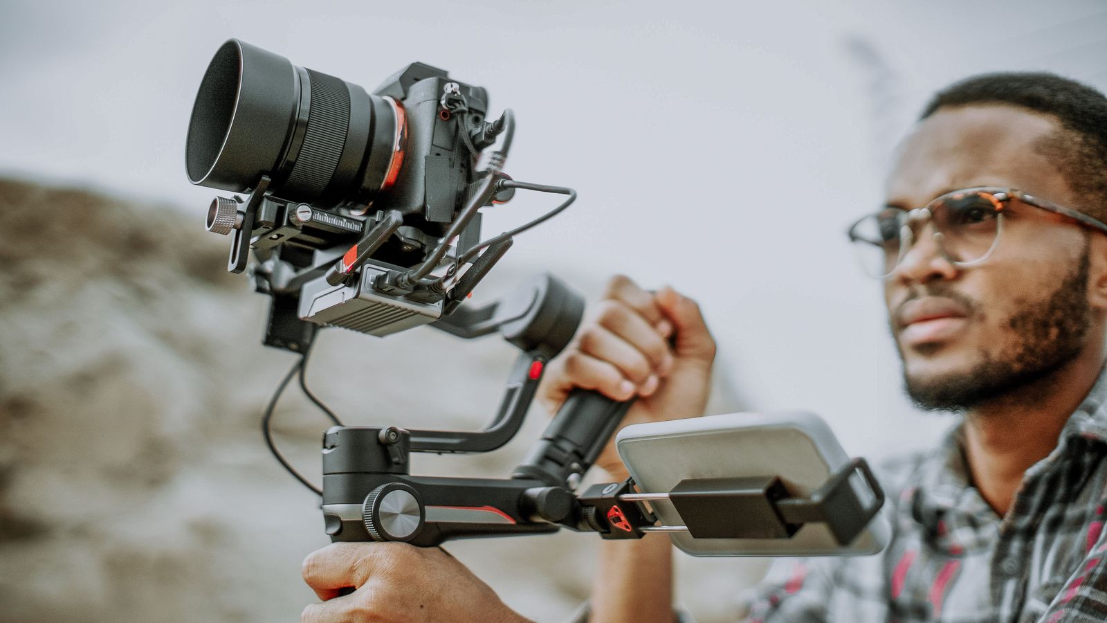 A videographer with a camera gimbal — filming with camels