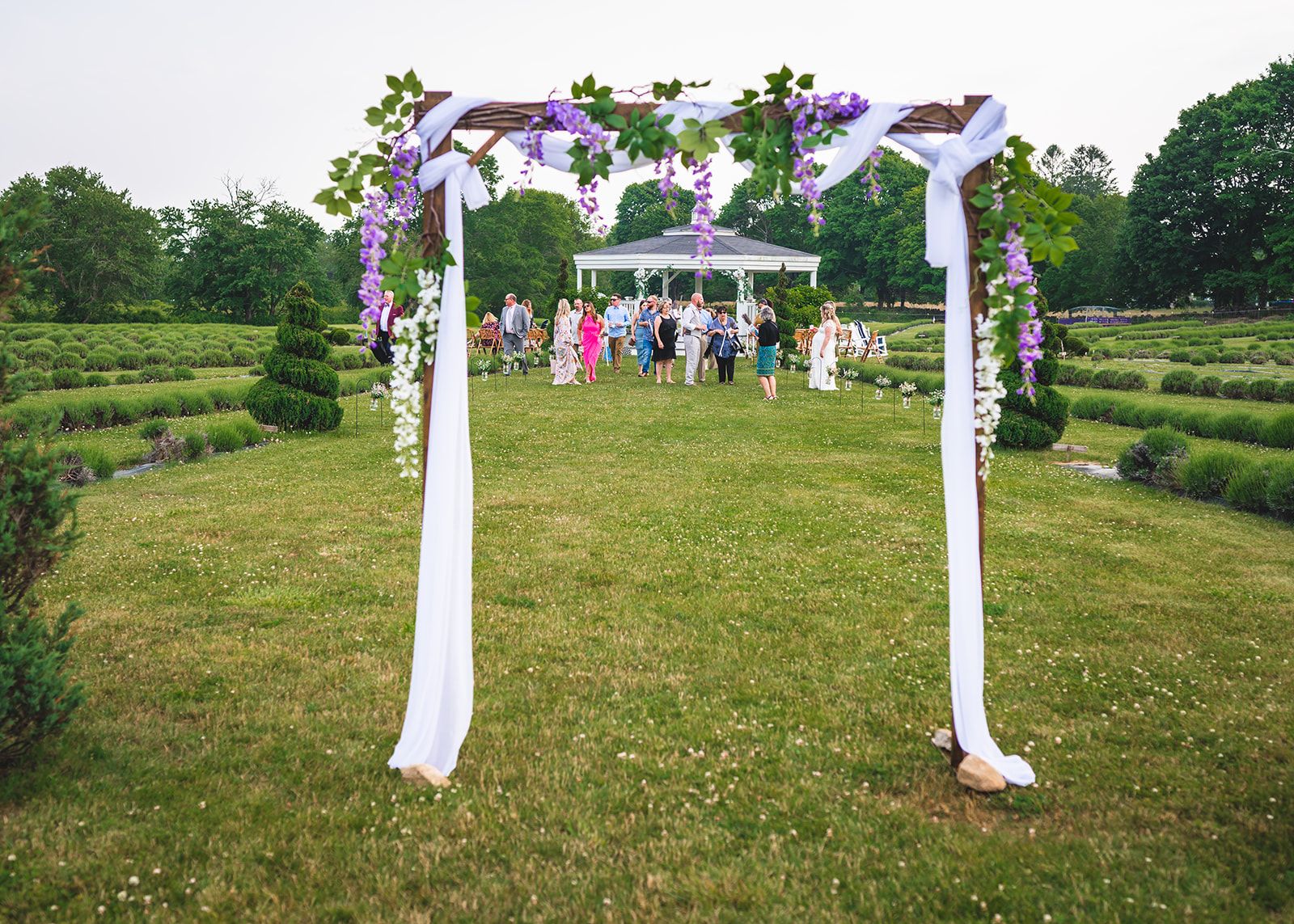 A wedding ceremony arch dressed with flowers in the lavender field