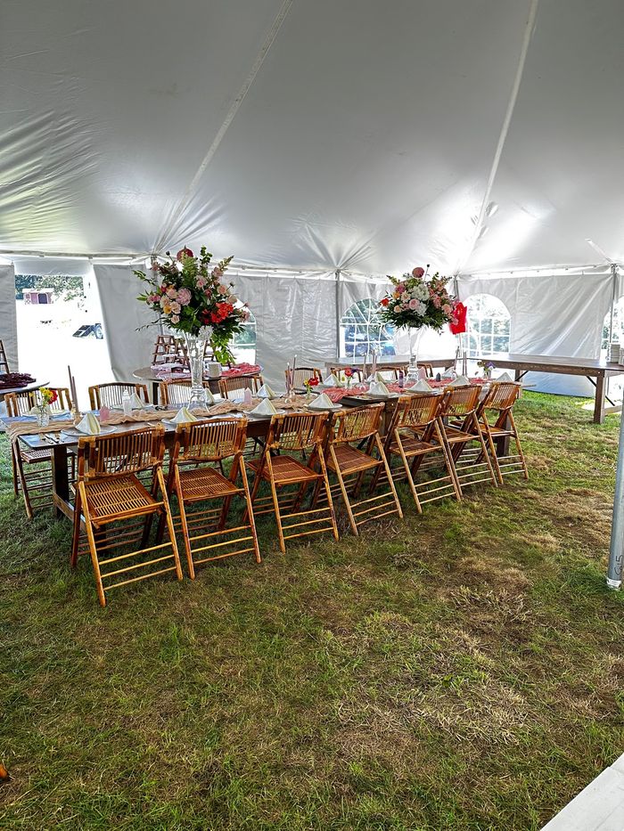 The farm's wooden farm tables set for a wedding dinner inside the tent